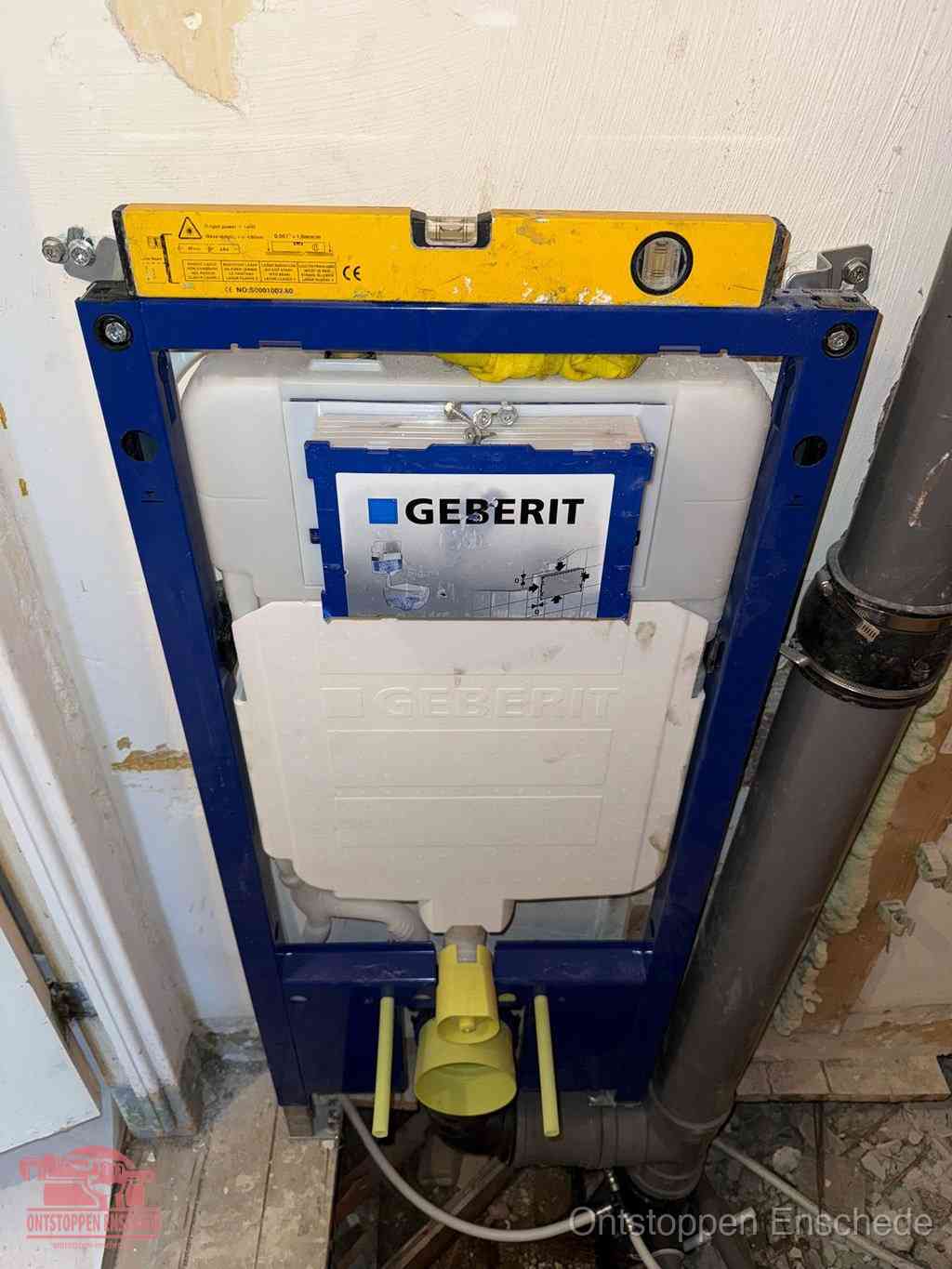 Een Geberit inbouwreservoir met frame voor een hangtoilet tegen de wand, met de afvoerbocht naar de vloer, kenmerkend voor een verstopt hangtoilet in Enschede