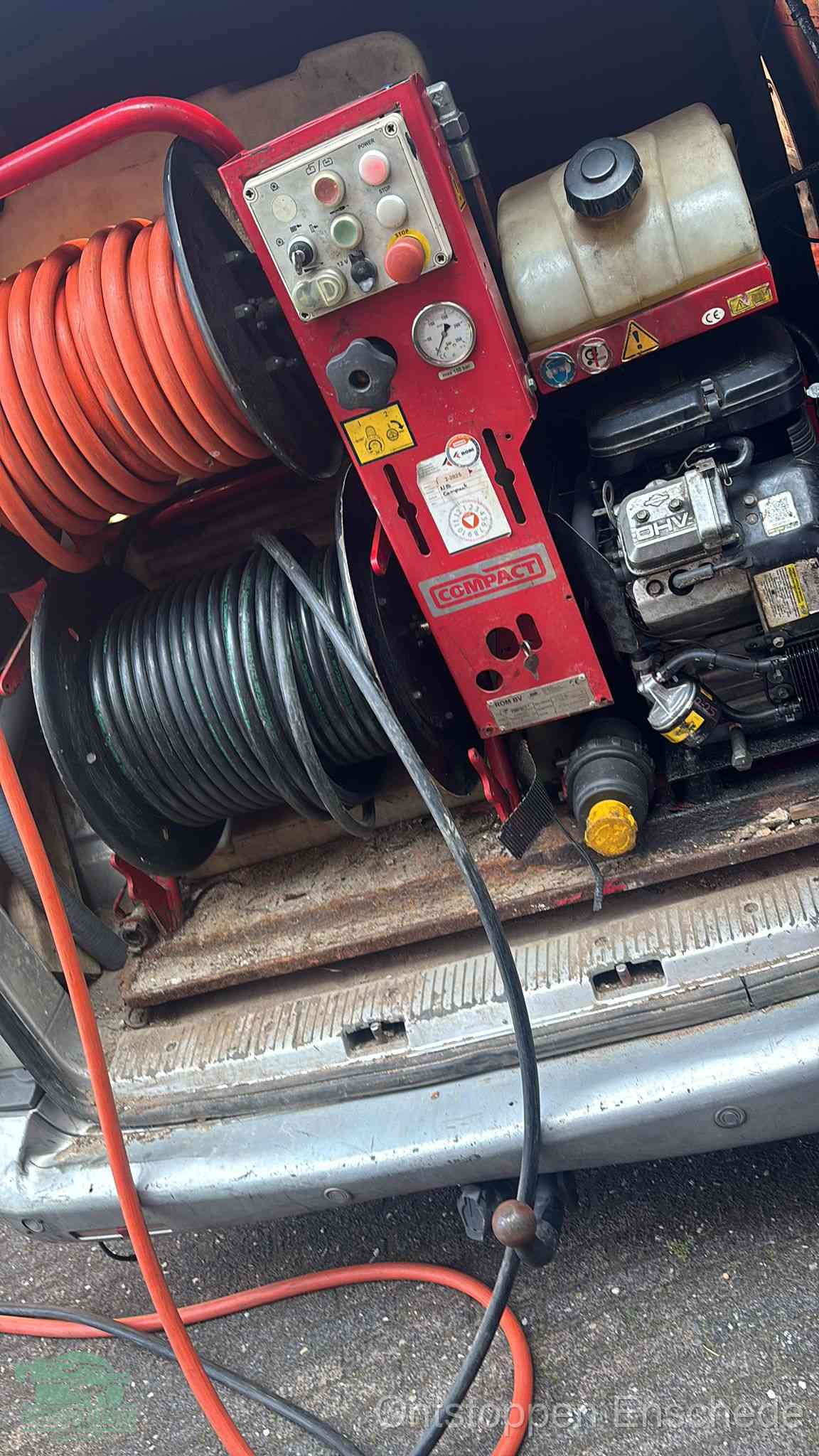 Een rood hogedruk-rioolreinigingstoestel in de laadbak van de bedrijfsbus, apparatuur voor een hardnekkige afvoerverstopping in Enschede