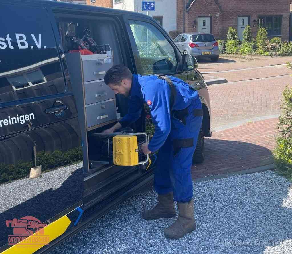 Een monteur pakt apparatuur uit de bedrijfsbus voor service aan huis, het moment om een professional in te schakelen voor een verstopte wc in Enschede