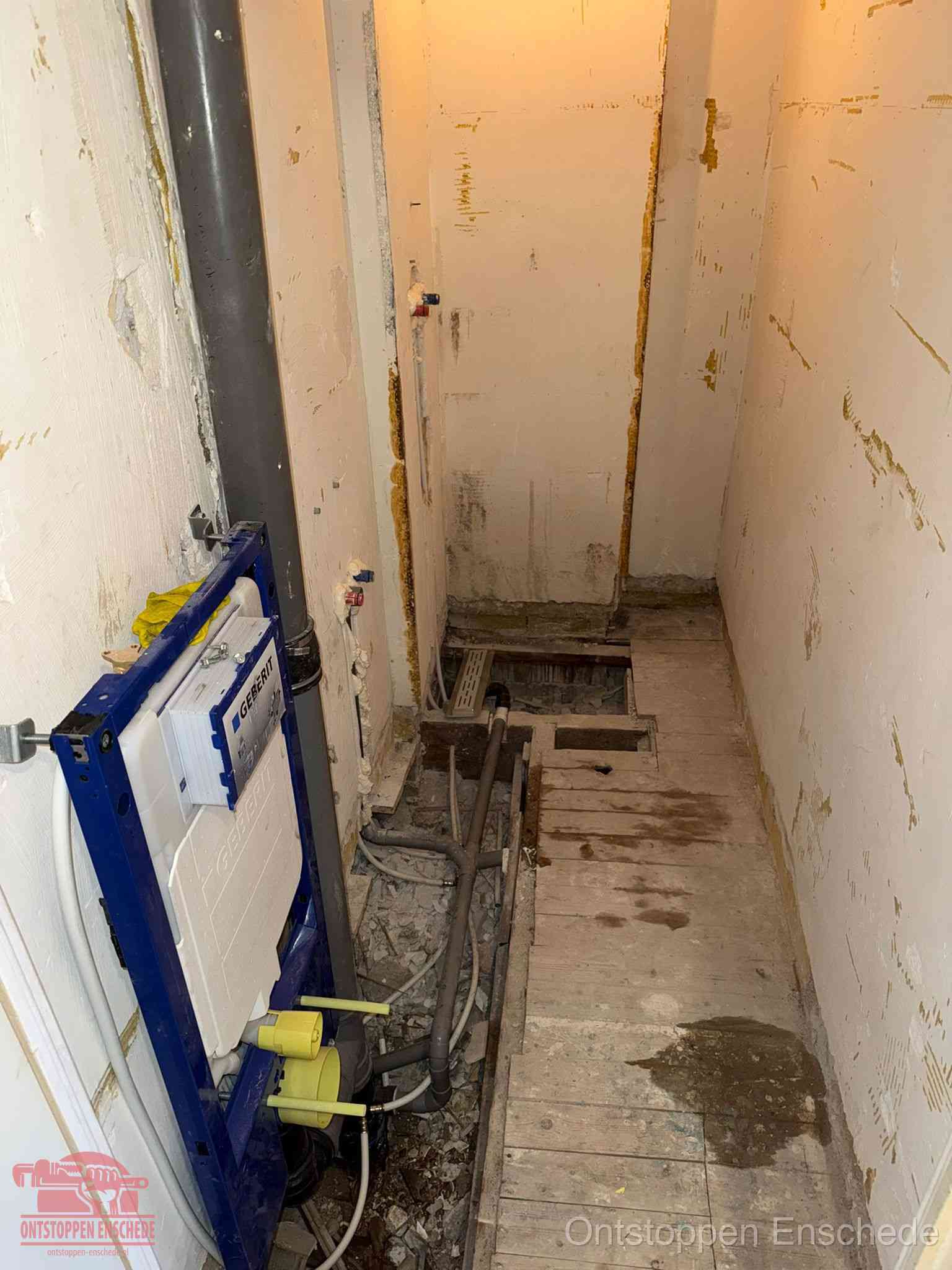 Een opgebroken toiletruimte tijdens renovatie met een Geberit inbouwreservoir en blootliggende oude afvoerleidingen, typisch voor oudere woningen in Enschede